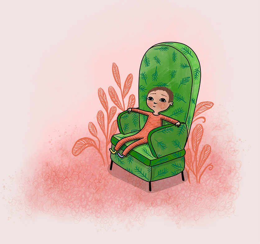 En liten pojke sitter i en grön fåtölj